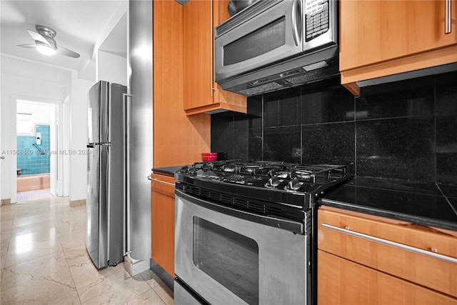 kitchen with stainless steel appliances, ceiling fan, and tasteful backsplash