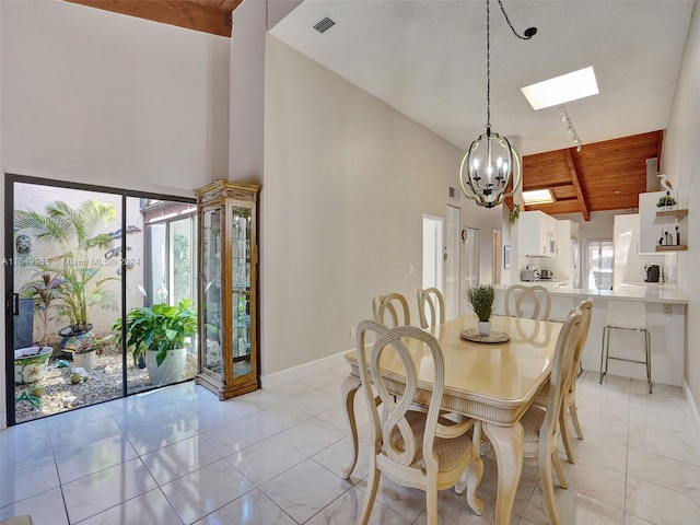 tiled dining room with high vaulted ceiling, a skylight, beamed ceiling, wood ceiling, and a notable chandelier