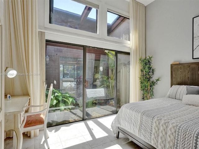 tiled bedroom featuring a skylight and access to exterior