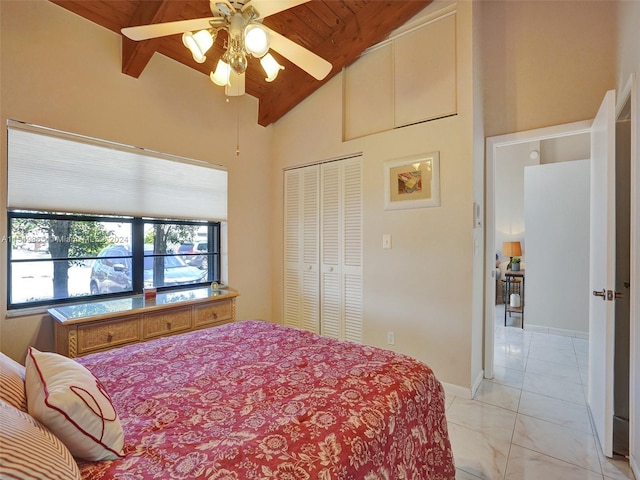 bedroom featuring wood ceiling, a closet, ceiling fan, and light tile floors