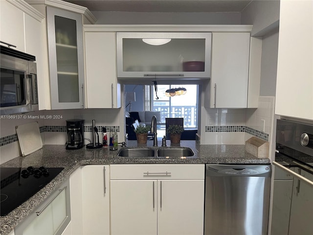 kitchen with sink, backsplash, white cabinetry, and stainless steel appliances