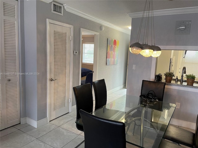 tiled dining space featuring crown molding and sink