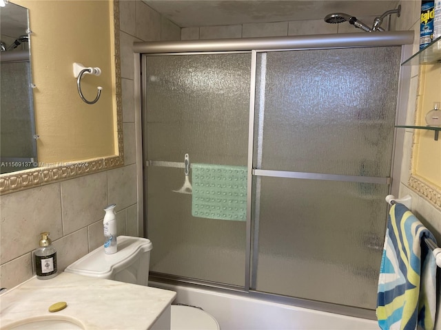 full bathroom featuring vanity, tile walls, backsplash, bath / shower combo with glass door, and toilet