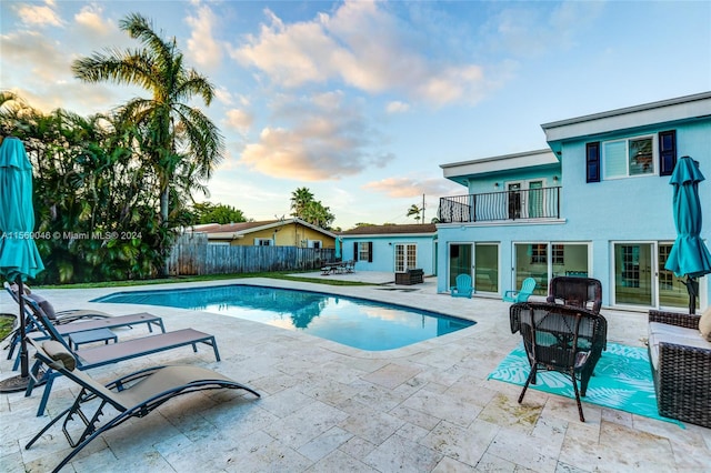 pool at dusk with a patio