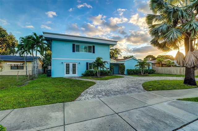 view of front of home with french doors and a yard