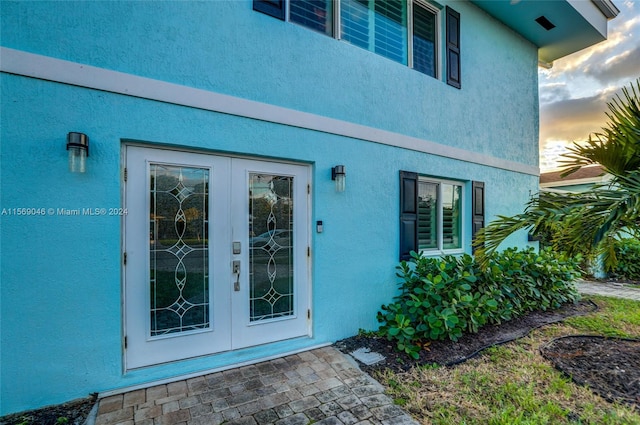 exterior entry at dusk featuring french doors