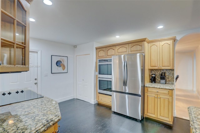 kitchen featuring light brown cabinets, light stone countertops, tasteful backsplash, and stainless steel appliances