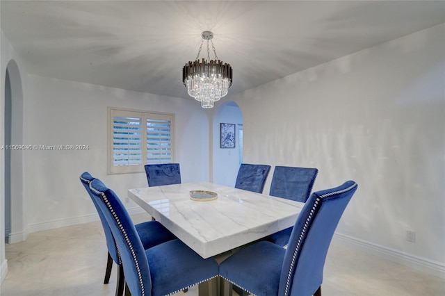 dining area with light tile patterned flooring and an inviting chandelier