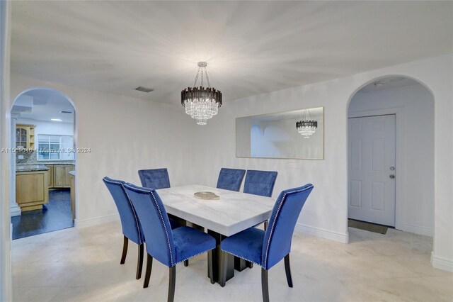 tiled dining room featuring a notable chandelier