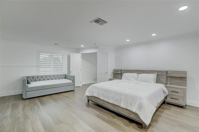 bedroom featuring light hardwood / wood-style floors and crown molding