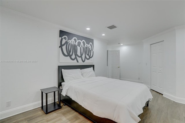 bedroom with wood-type flooring and ornamental molding