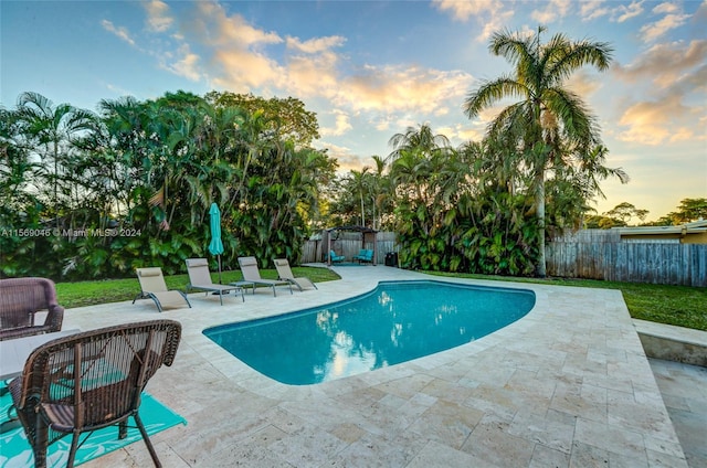 pool at dusk with a patio