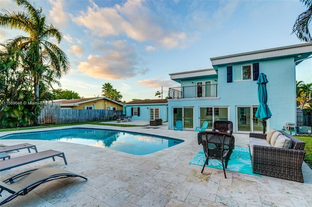 pool at dusk with a patio area