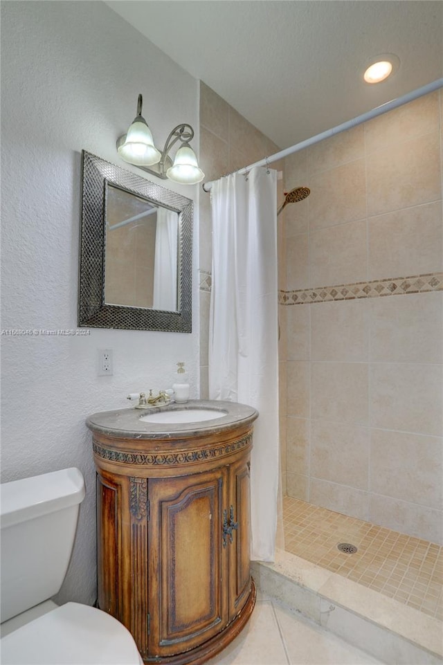 bathroom featuring vanity, toilet, tile patterned flooring, and walk in shower