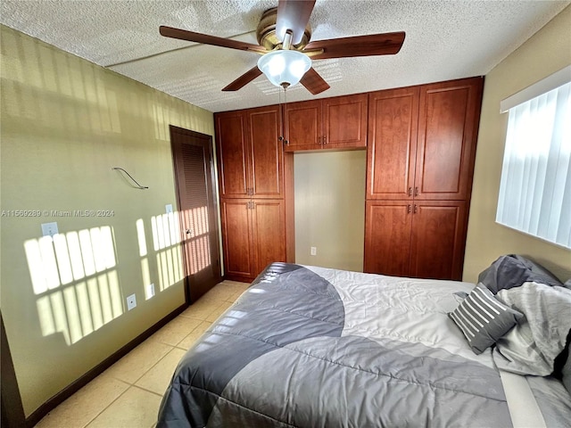 bedroom featuring a textured ceiling, ceiling fan, and light tile flooring