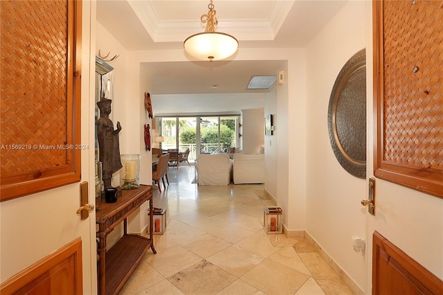 hallway featuring a raised ceiling and light tile floors