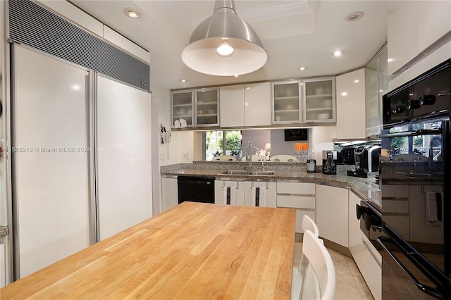 kitchen with sink, white cabinetry, hanging light fixtures, and black appliances