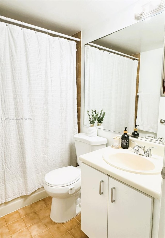 full bathroom with tile patterned flooring, vanity, toilet, and shower / bath combo with shower curtain