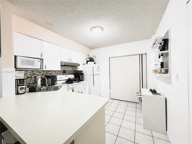 kitchen featuring white appliances, white cabinets, sink, a textured ceiling, and kitchen peninsula