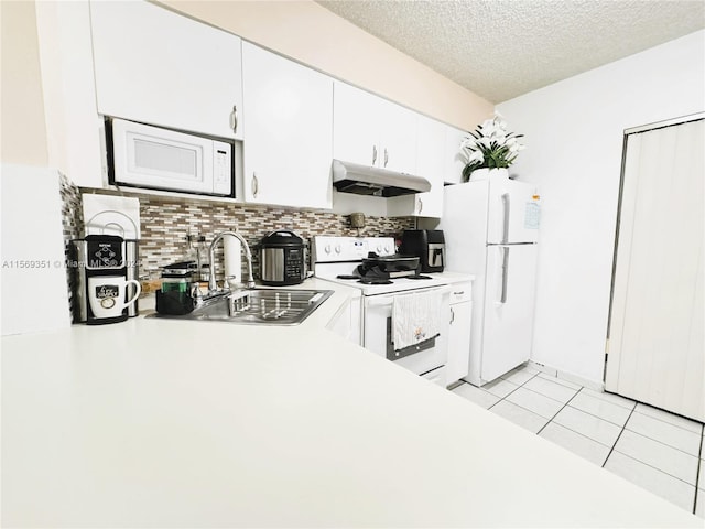 kitchen featuring sink, light tile patterned flooring, a textured ceiling, white appliances, and white cabinets