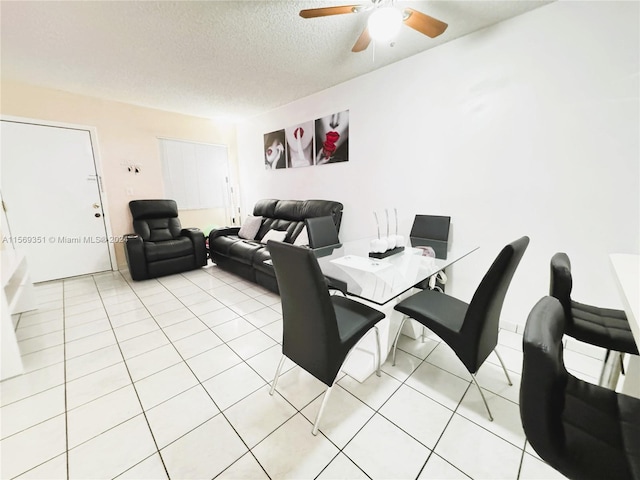 dining area with ceiling fan, light tile patterned floors, and a textured ceiling