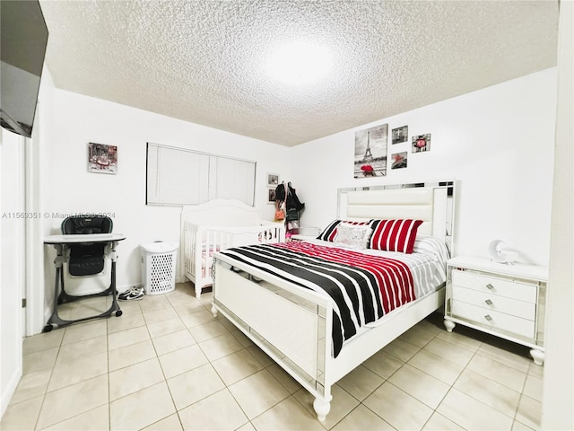 bedroom with light tile patterned floors and a textured ceiling