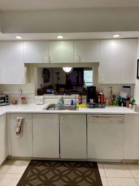 kitchen featuring white cabinets, light tile flooring, sink, and dishwasher