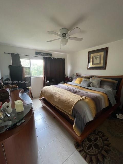 tiled bedroom featuring ceiling fan