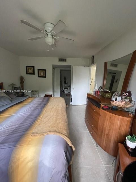 bedroom with ceiling fan and light tile floors