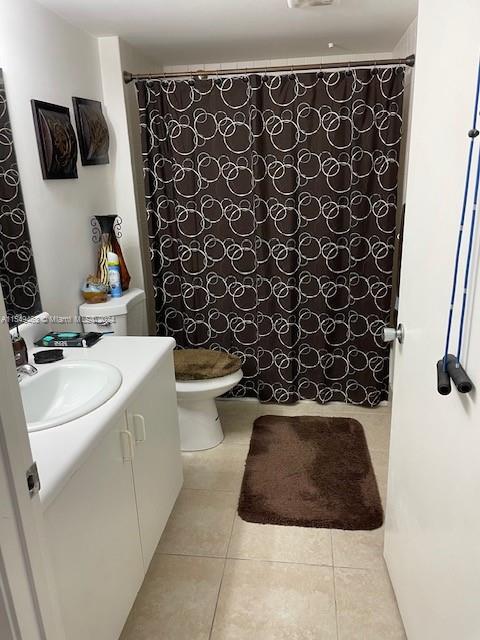 bathroom with toilet, tile floors, and vanity