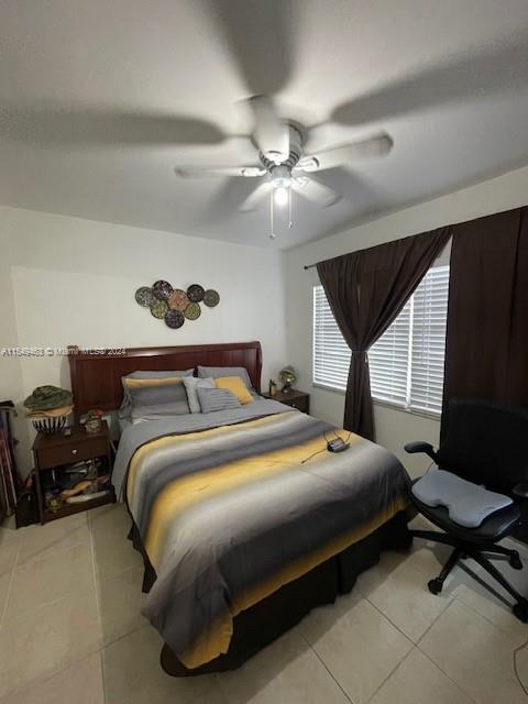 bedroom featuring ceiling fan and light tile floors