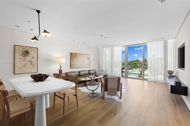 dining room with expansive windows and light hardwood / wood-style floors