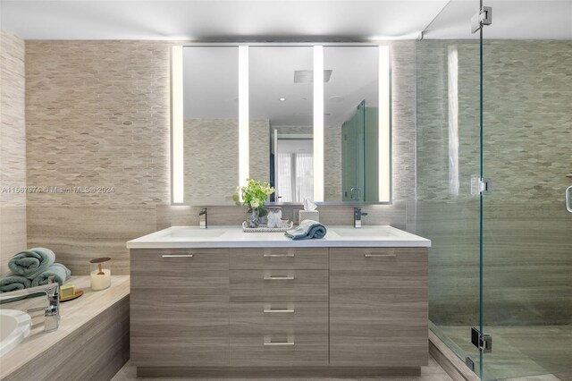 bathroom featuring vanity, tile walls, and a shower with shower door