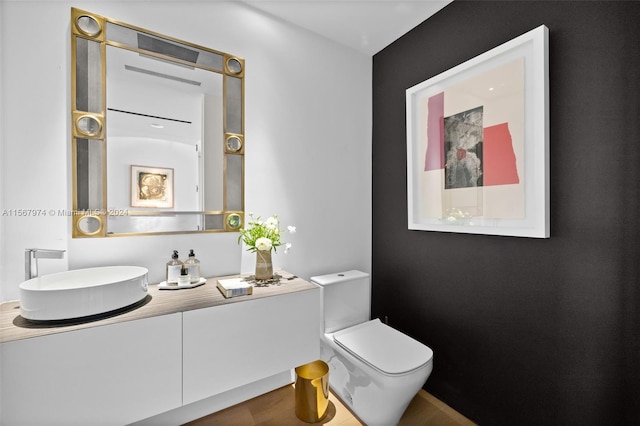 bathroom featuring vanity, toilet, and hardwood / wood-style flooring