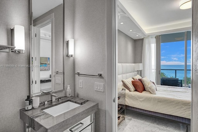 interior space with light tile flooring, sink, and a water view