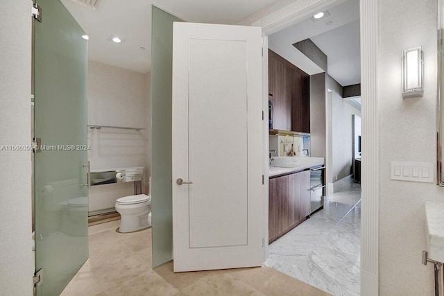 bathroom with tile flooring, vanity, and toilet