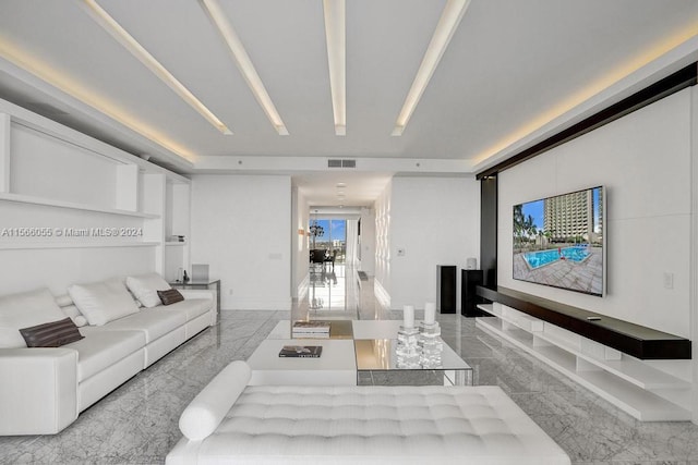 living room with a tray ceiling and light tile floors