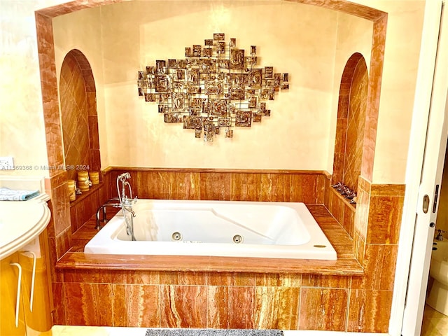 bathroom with toilet and tiled bath