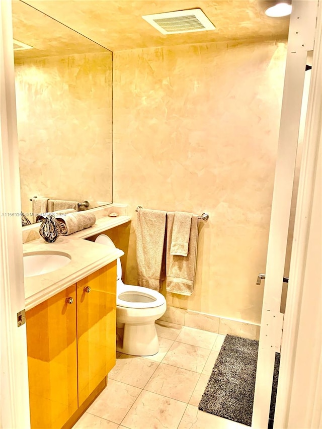 bathroom featuring vanity, toilet, and tile flooring