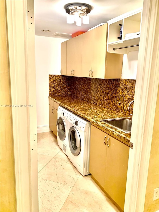 washroom with cabinets, independent washer and dryer, light tile floors, and sink