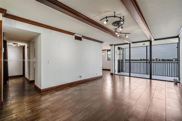 empty room featuring ornamental molding and a textured ceiling