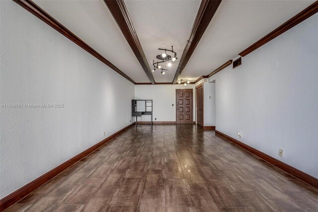 unfurnished living room with track lighting, expansive windows, and crown molding