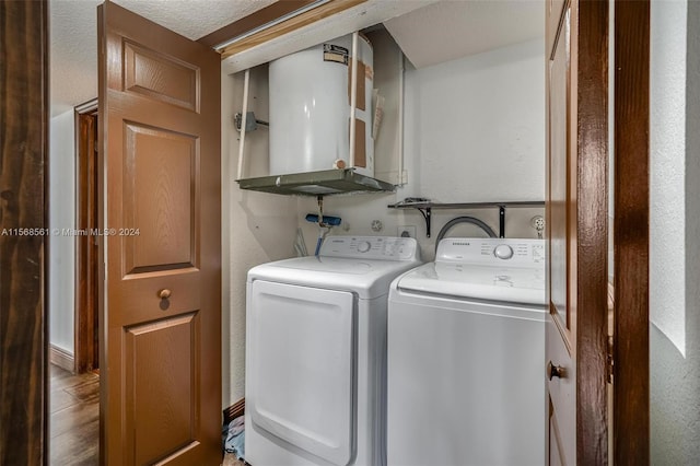 laundry room featuring washer and dryer, cabinets, a textured ceiling, and water heater