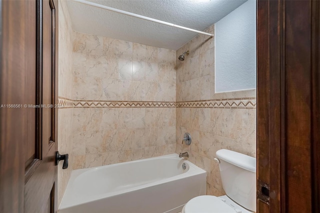 bathroom featuring tile walls, tiled shower / bath combo, a textured ceiling, and toilet