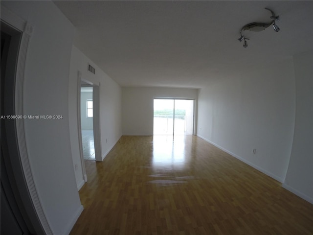 empty room featuring track lighting and hardwood / wood-style floors