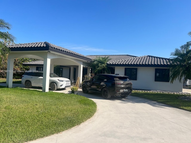 view of front of home with a front lawn and a carport