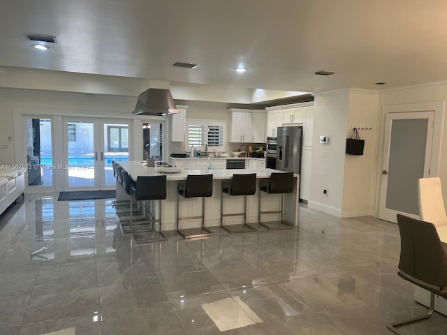 kitchen with white cabinets, a breakfast bar area, a kitchen island, and french doors