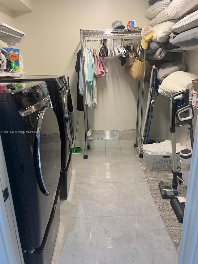 laundry room with washing machine and dryer and light tile flooring