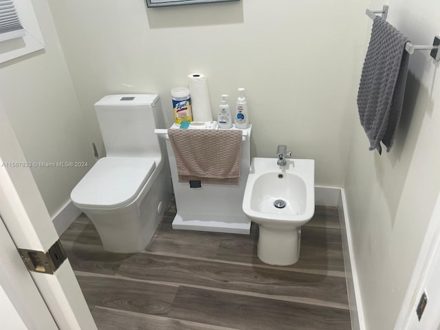 bathroom featuring hardwood / wood-style floors, toilet, and a bidet