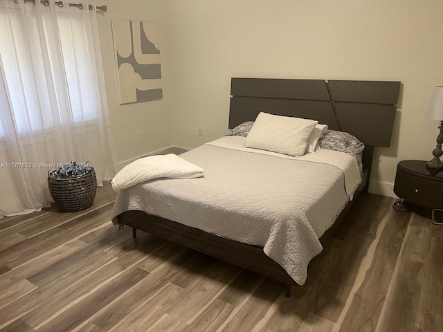 bedroom with dark hardwood / wood-style floors